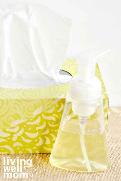 a bottle of homemade soap with essential oils next to a box of tissues