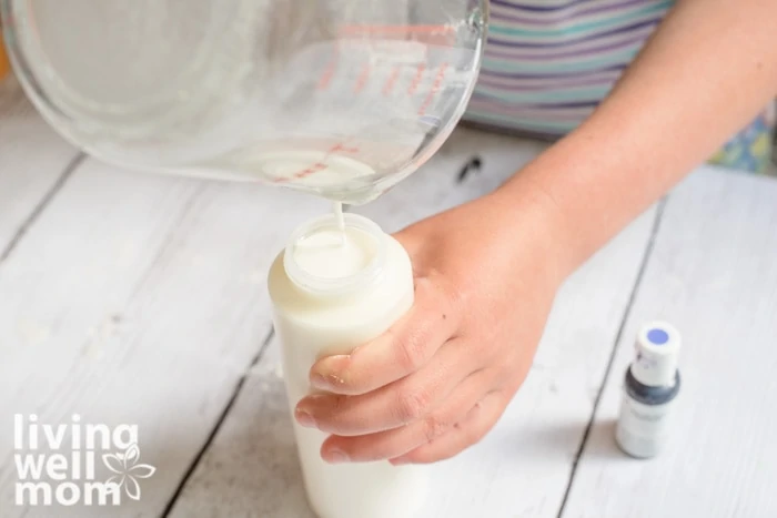 Pouring diy sidewalk paint mixture into squirt bottles