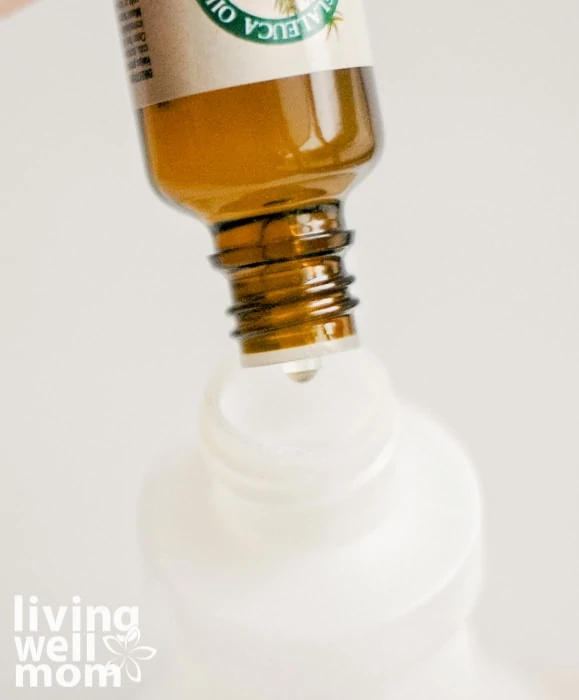 tea tree oil being poured into lice prevention spray
