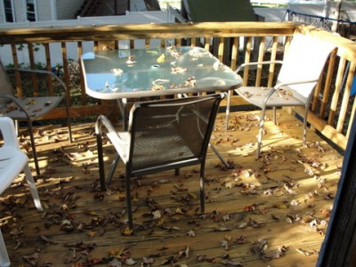 leaves falling on patio furniture and wood deck