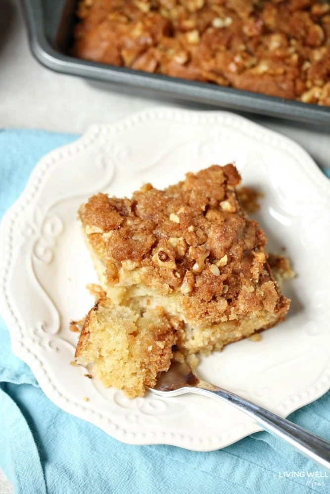 A serving of breakfast coffee cake with apples on a white dish.