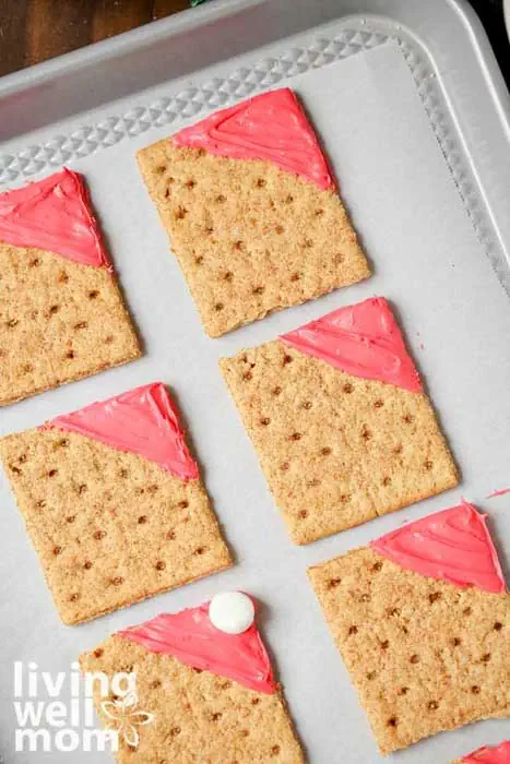 adding red icing to a graham cracker