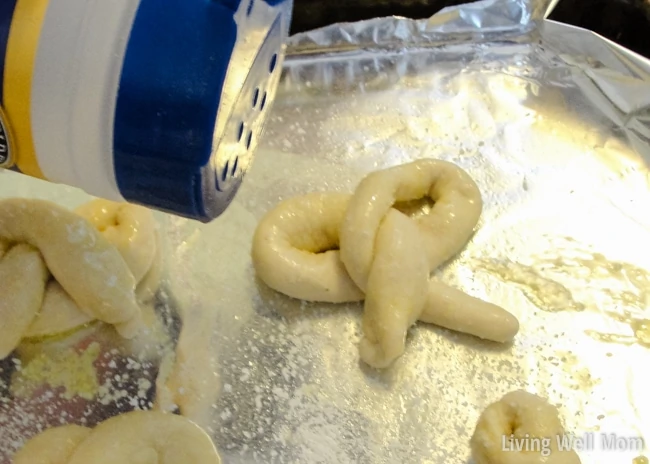 pouring salt over unbaked pretzel 