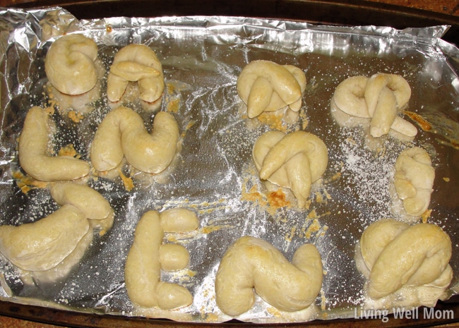 soft pretzels in shapes on a foil lined baking sheet