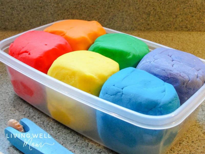 6 balls of homemade playdough in a plastic container. 