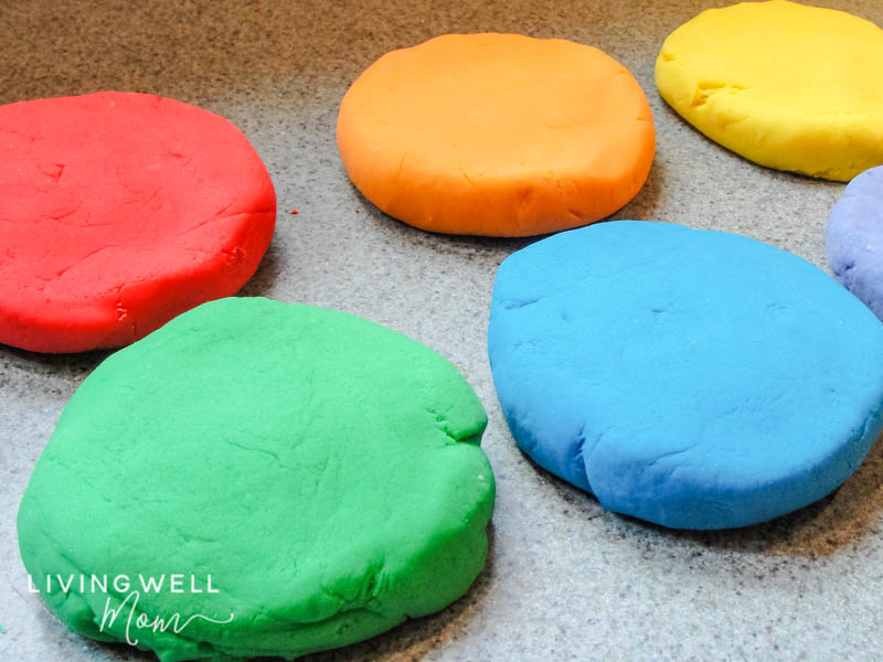 Colorful batches of homemade playdough on a countertop 