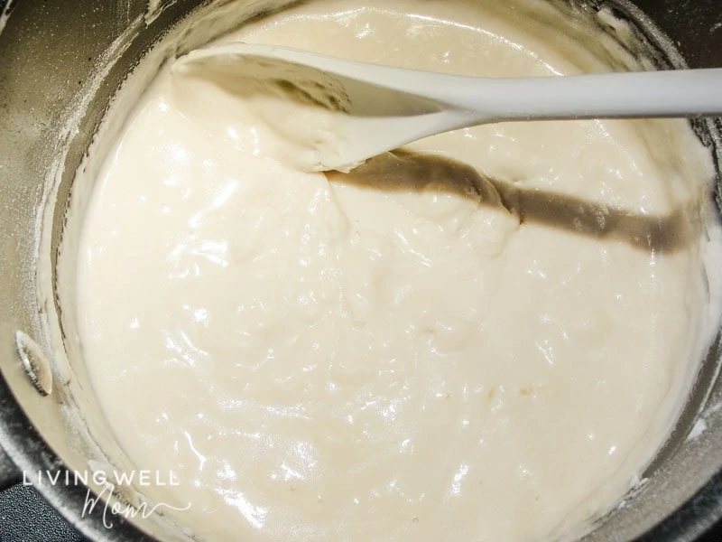 Lumpy dough batter being mixed with a large spoon.
