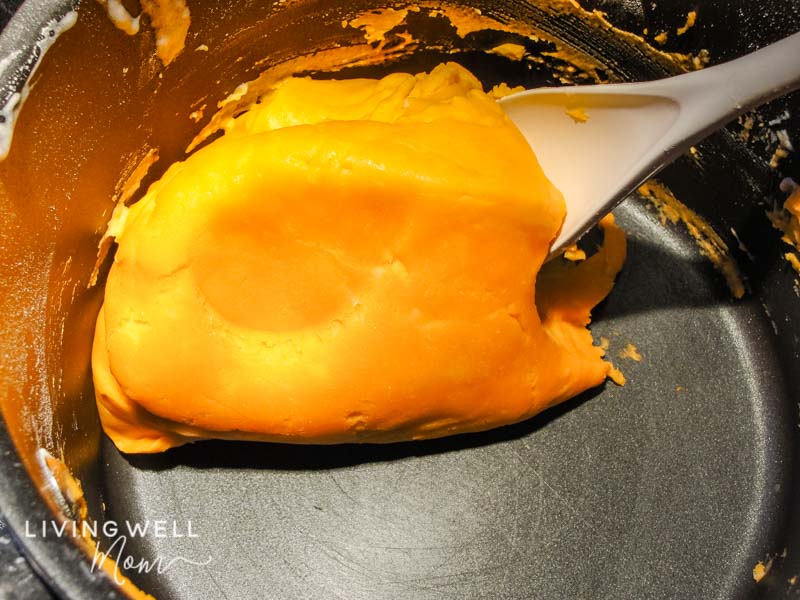 Soft, orange playdough in a saucepan. 
