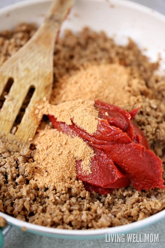 Meat mixture for sloppy joes being stirred together with a wooden spoon.