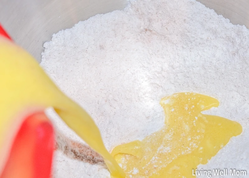 adding orange juice mixture to flour for carrot cake