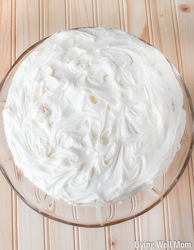white frosted cream cheese carrot cake on a cake plate
