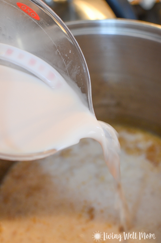 pouring milk into a pan for homemade macaroni and cheese