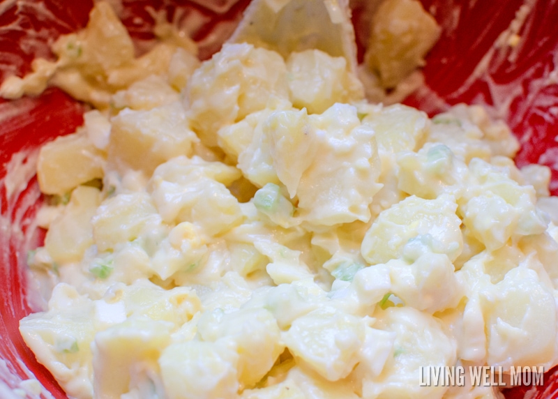 mixing potato salad dressing into potatoes celery and eggs