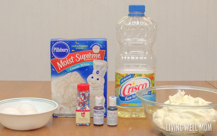 ingredients for cupcakes recipe - eggs in a bowl, cake mix, oil, sprinkles, frosting