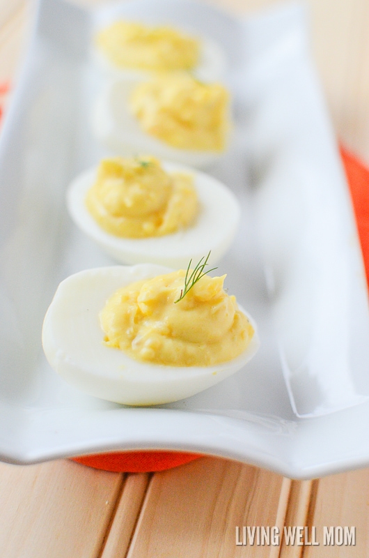deviled eggs in a row on a white platter 