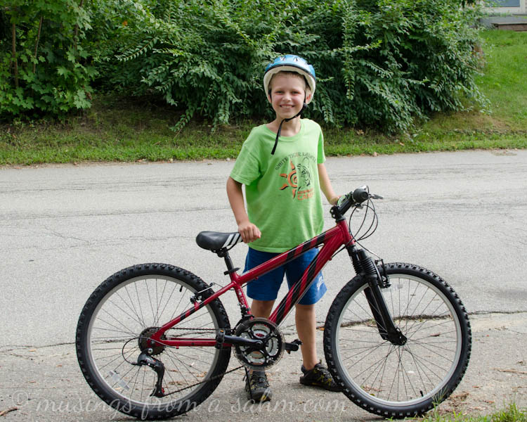 A little boy wearing a helmet and riding a bicycle