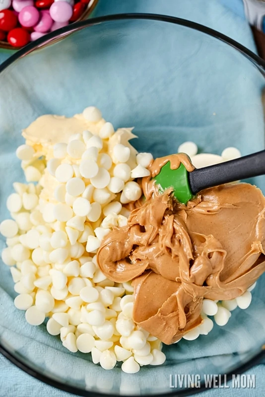 white chocolate chips and creamy peanut butter being combined with a spoon
