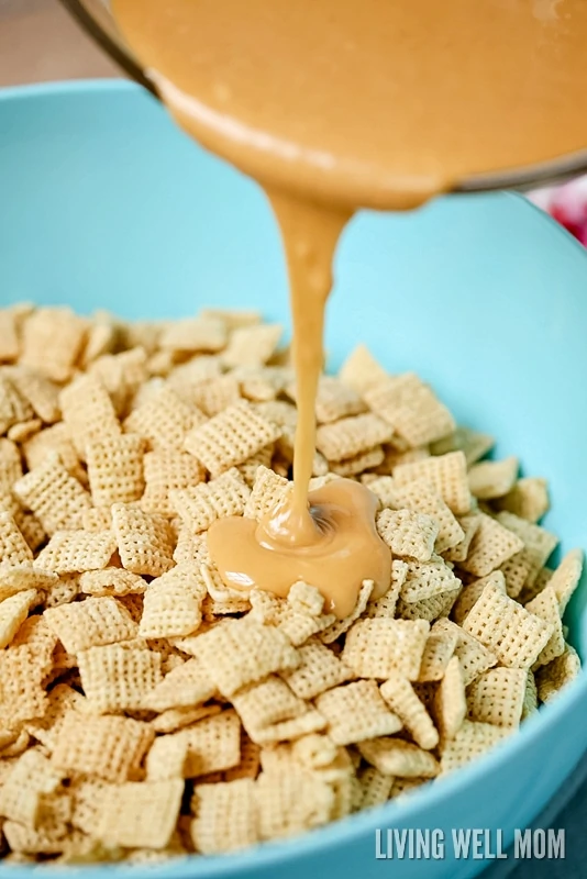peanut butter chocolate mixture be9ing drizzled onto Chex cereal