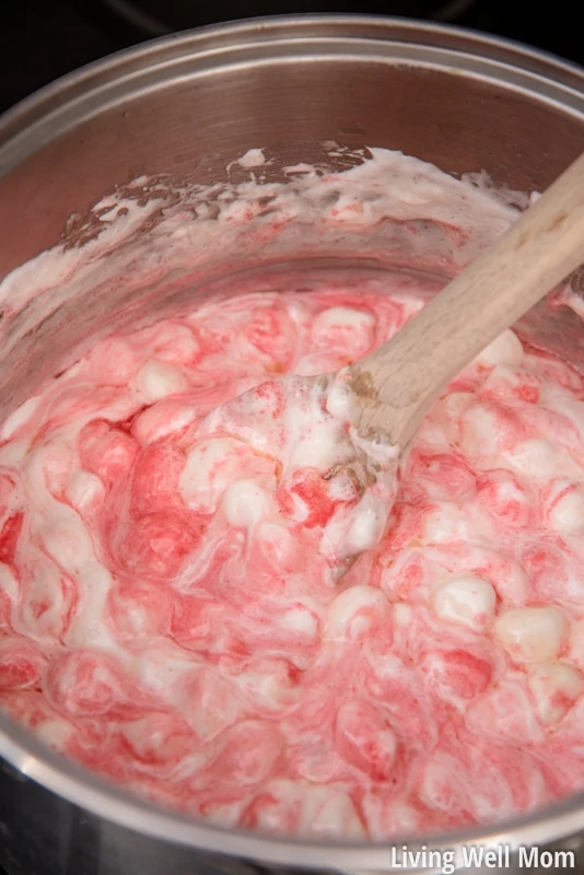 Mixing strawberry gelatin with melted marshmallows