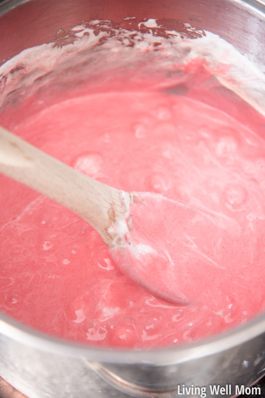 Stirring melted marshmallows and pink gelatin