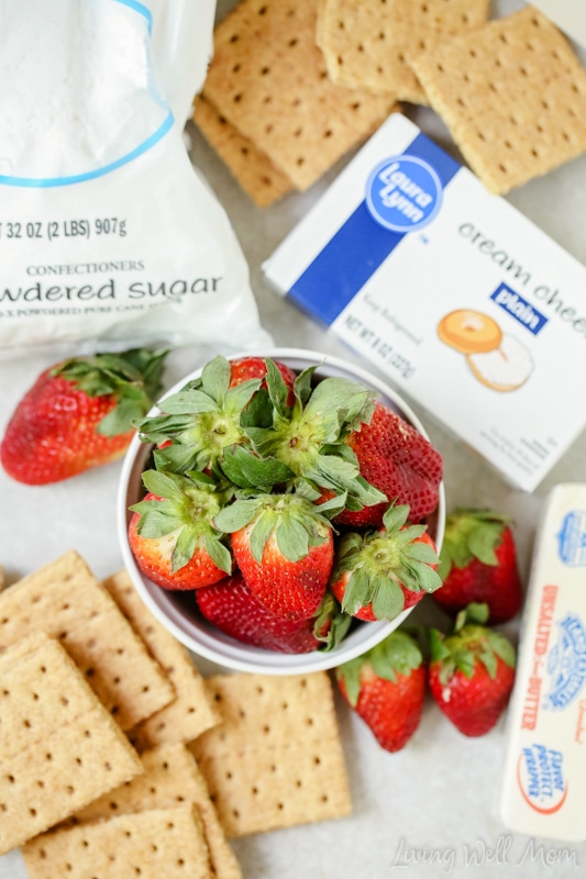 Ingredients for Strawberry Cheesecake cupcakes on a counter, including fresh berries. 