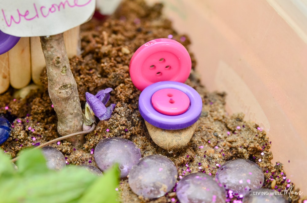 DIY fairy chairs stuck into the dirt of a homemade fairy garden. 