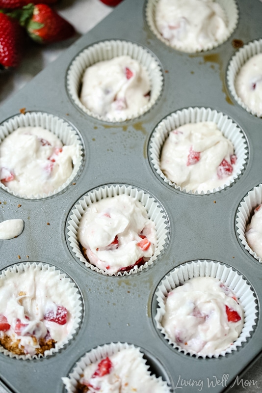 Muffin liners in a tin filled with cupcake batter. 