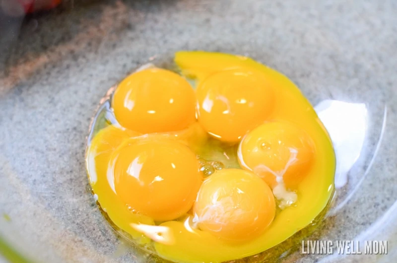 five egg yolks in a clear mixing bowl 