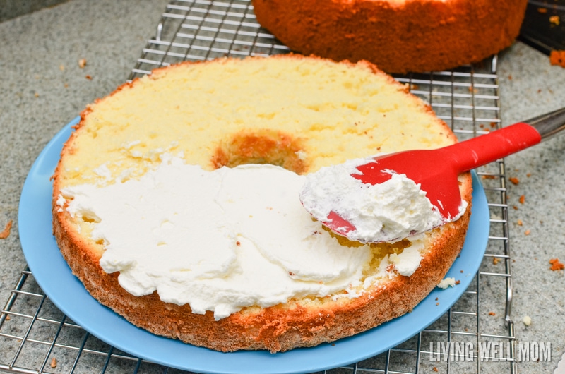 whipped cream icing being spread onto a cake layer