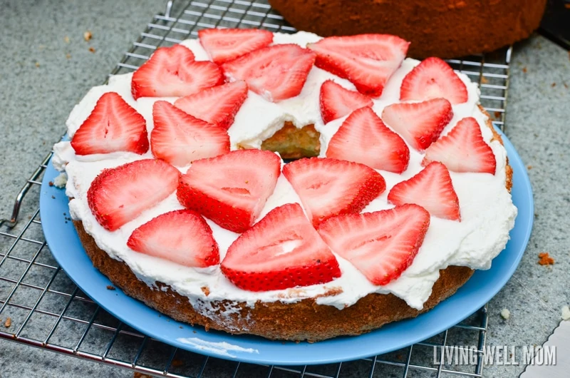 a layer of sliced strawberries on a fresh baked cake 