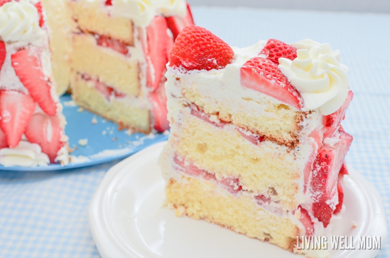 a large slice of three layer homemade cake with fresh strawberries