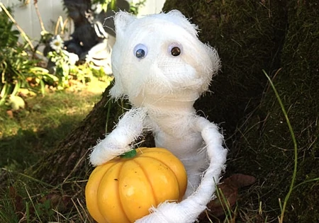 diy mummy holding a mini pumpkin