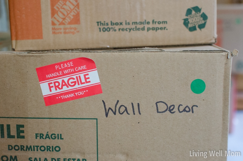 A moving box with a green sticker on the side, also labeled "Wall Decor." 