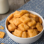 homemade cheese crackers in white bowl with blue place mat