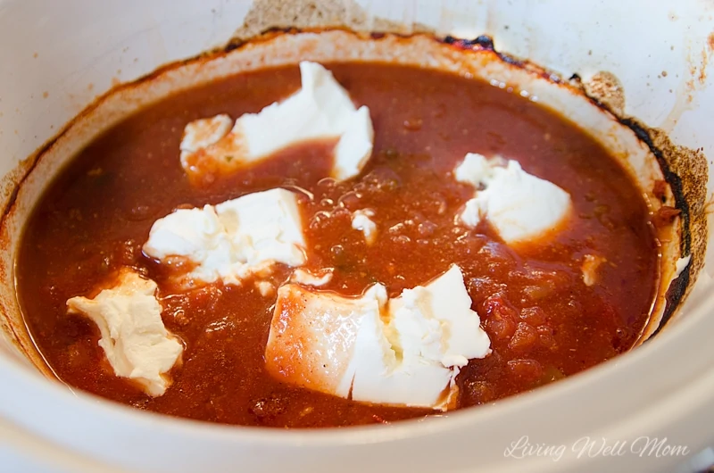 cream cheese cooking in salsa in a slow cooker