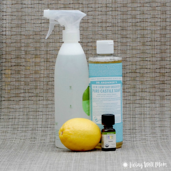 lemon, lemon essential oil bottle, castile soap, and spray bottle