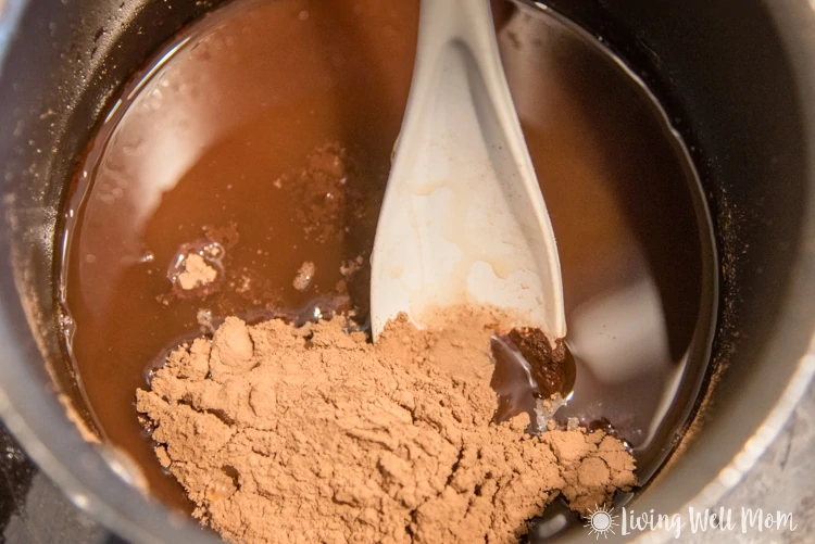 mixing together cocoa and maple syrup with coconut oil