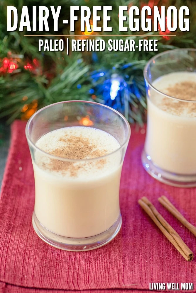 2 glasses of eggnog with cinnamon in front of a christmas tree