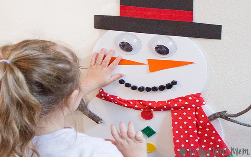 child playing pin the nose on the snowman