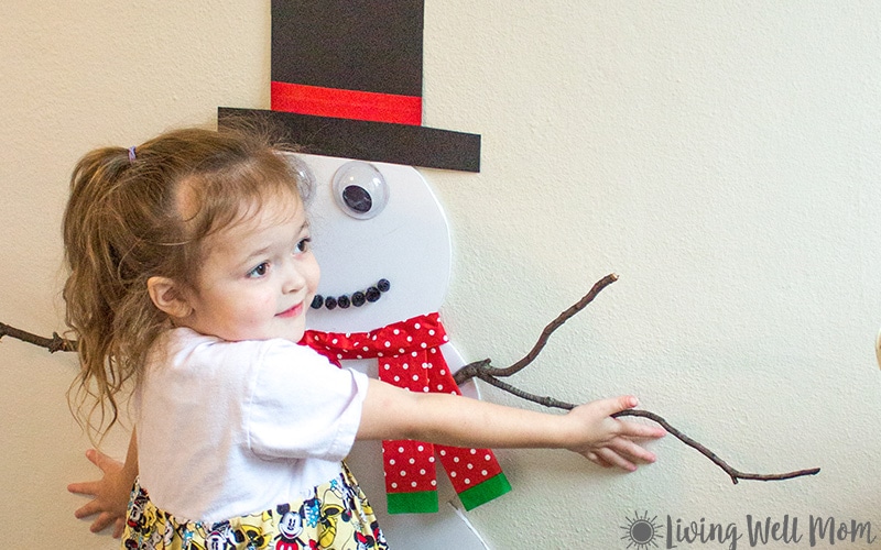 kid touching snowman game on a wall