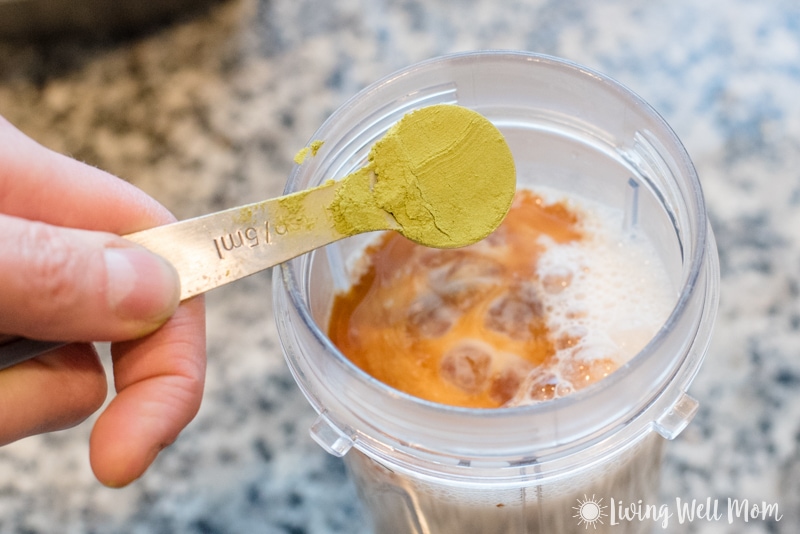 teaspoon of green matcha powder into blender cup with milk and vanilla extract