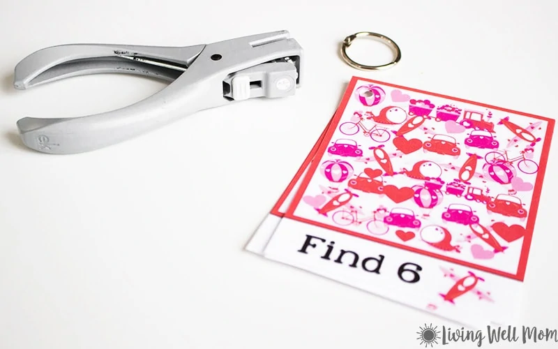 a holiday printable game on a white surface next to a hole punch and book ring