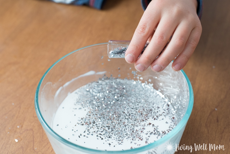 adding silver glitter into DIY slime mixture