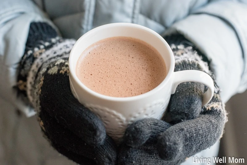 child holding cup of hot cocoa