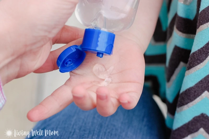 squeezing hand sanitizer onto child's hand