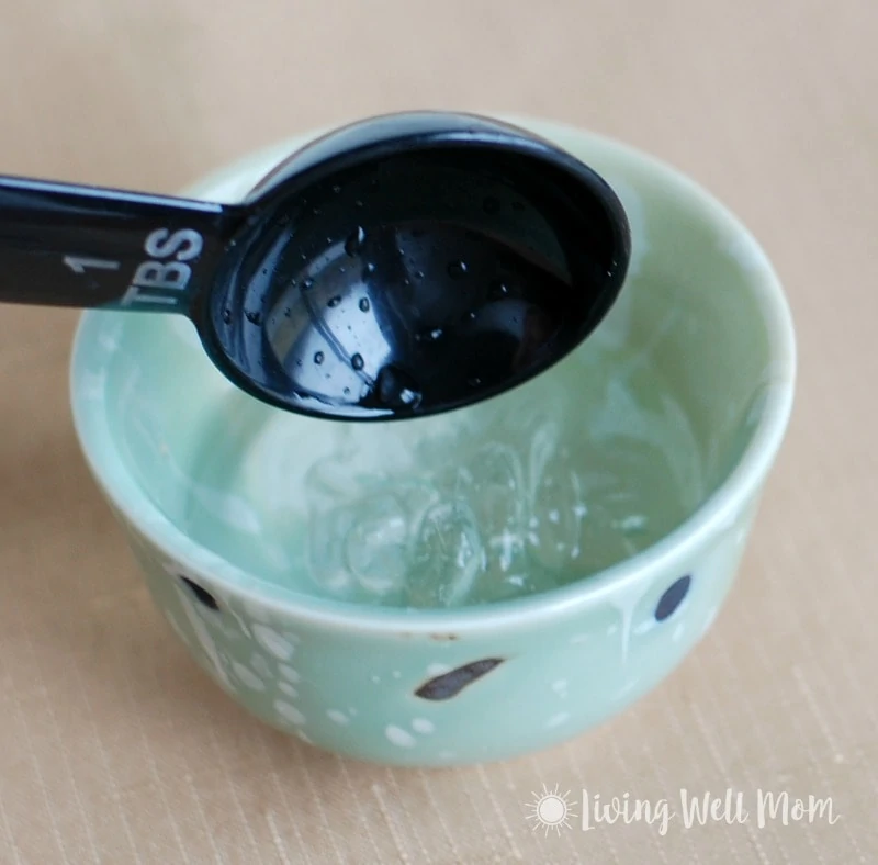measuring spoon over small green bowl with gel