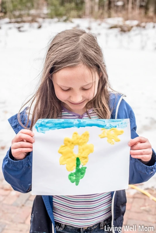 a girl holding puffy paint sunflower art