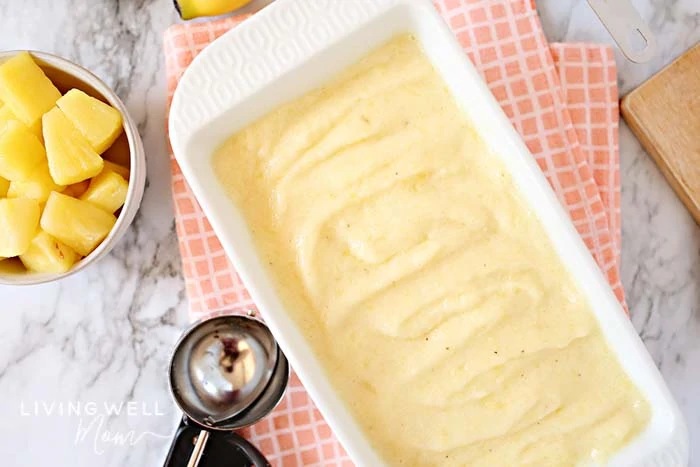 A bread pan filled with smooth pineapple ice cream.