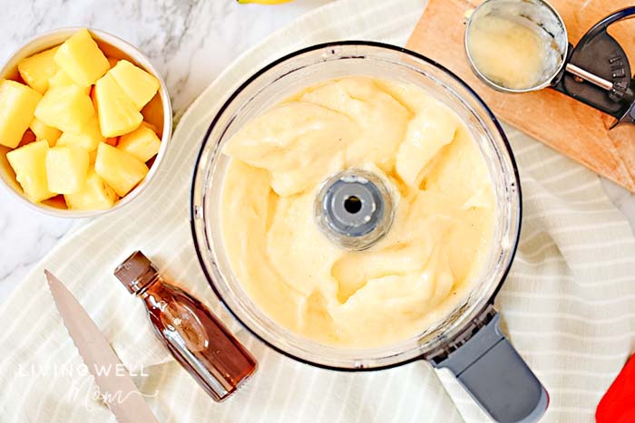 Blended pineapple Dole Whip ice cream in a food processor.