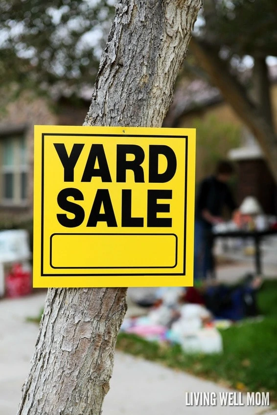 A yellow yard sale sign on a tree